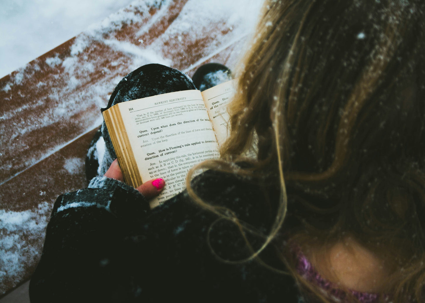 Photo by Will on Unsplash  of a girl reading in the snow